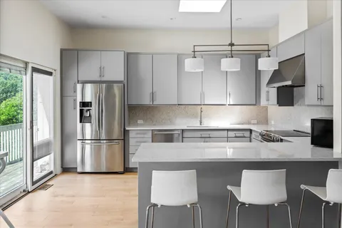 a kitchen with stainless steel appliances granite countertop a refrigerator and a stove top oven