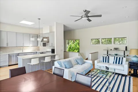 a living room with furniture kitchen view and a window