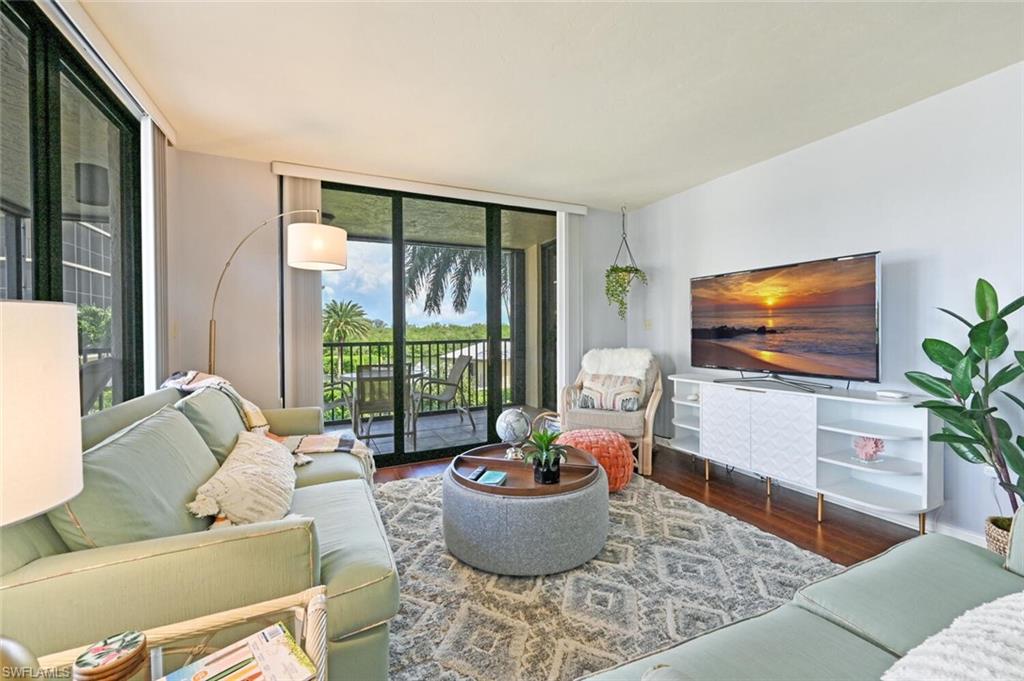17 Bluebill Avenue, Unit 101 Naples, FL 34108 - Photo 11 of 23 a living room with furniture and a flat screen tv