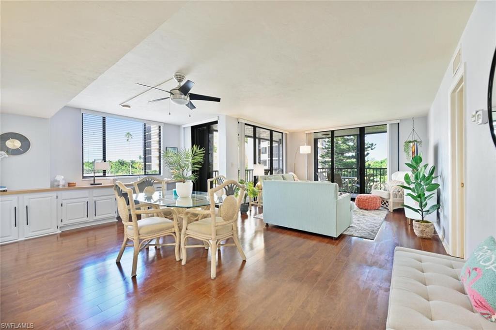 17 Bluebill Avenue, Unit 101 Naples, FL 34108 - Photo 13 of 23 a dining room with wooden floor and large windows
