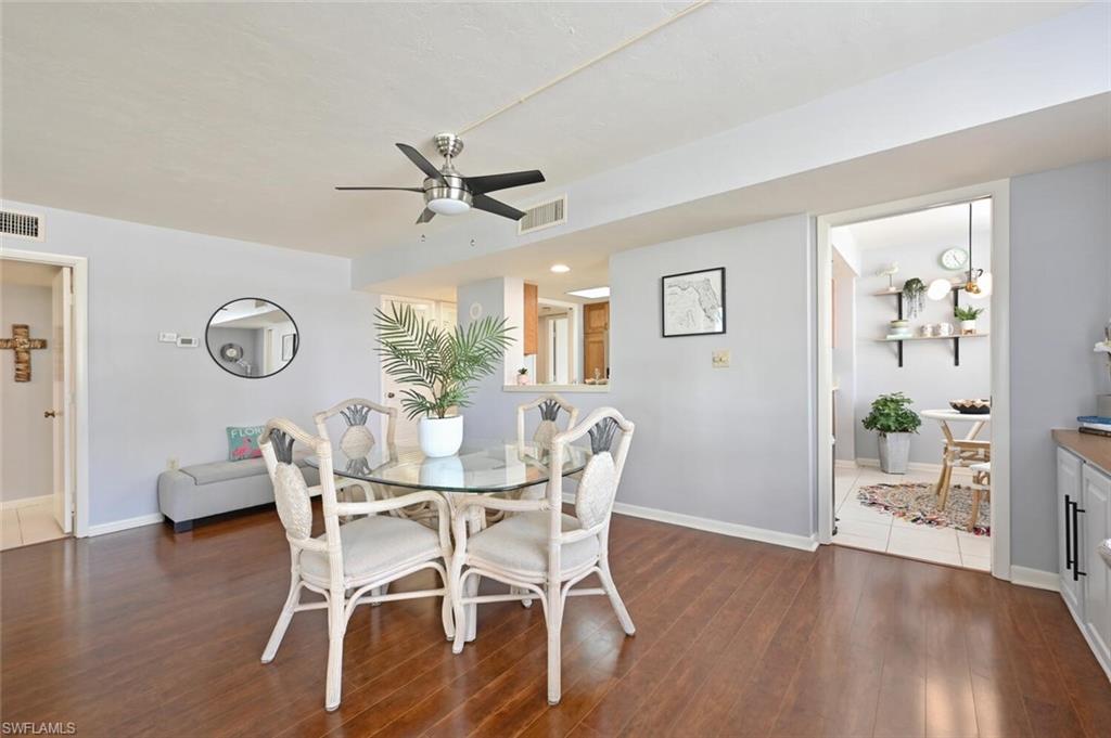 17 Bluebill Avenue, Unit 101 Naples, FL 34108 - Photo 14 of 23 a view of a dining room with furniture wooden floor and a chandelier