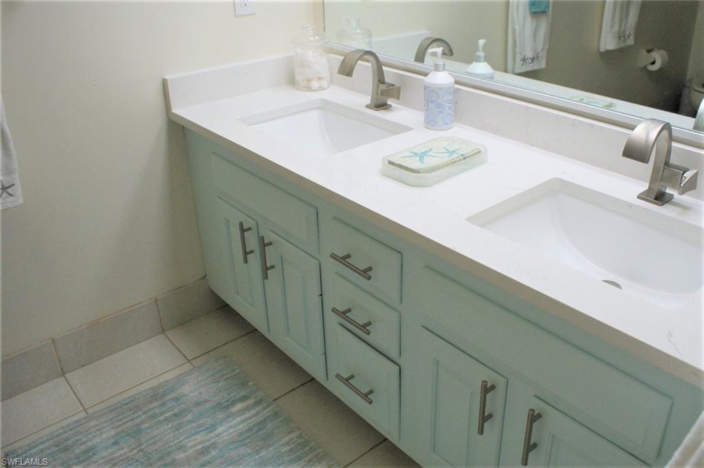 17 Bluebill Avenue, Unit 101 Naples, FL 34108 - Photo 17 of 23 a bathroom with a sink and a mirror