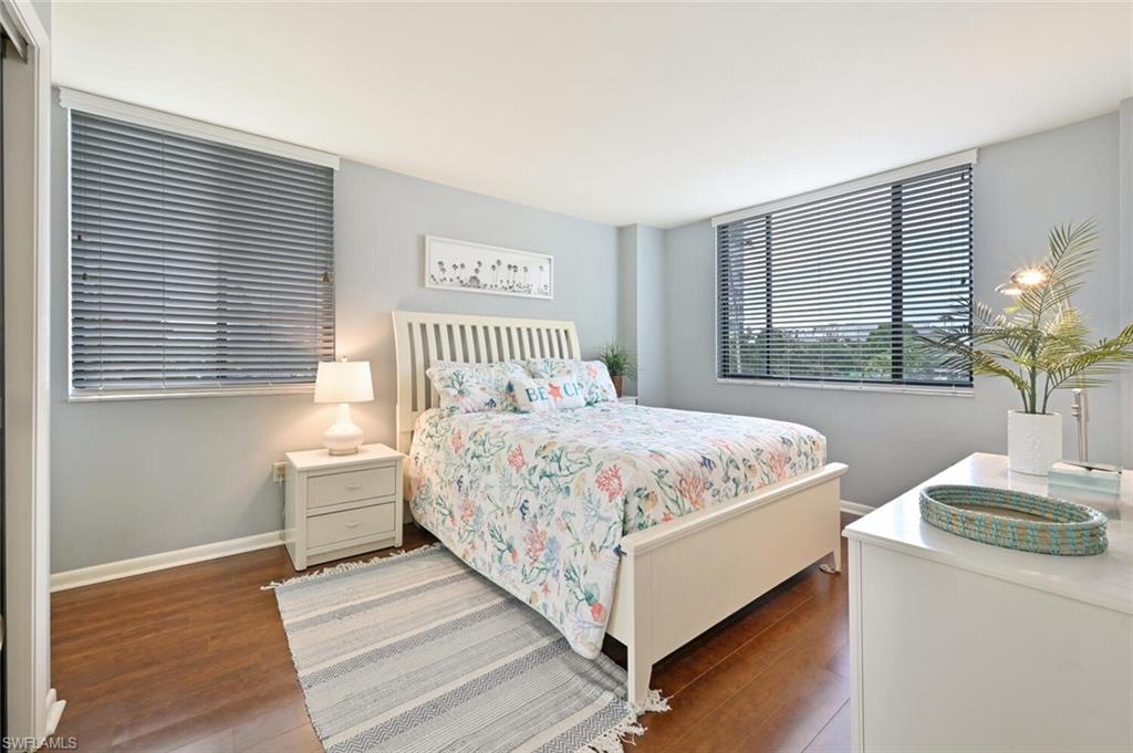 17 Bluebill Avenue, Unit 101 Naples, FL 34108 - Photo 18 of 23 a bedroom with a bed and windows