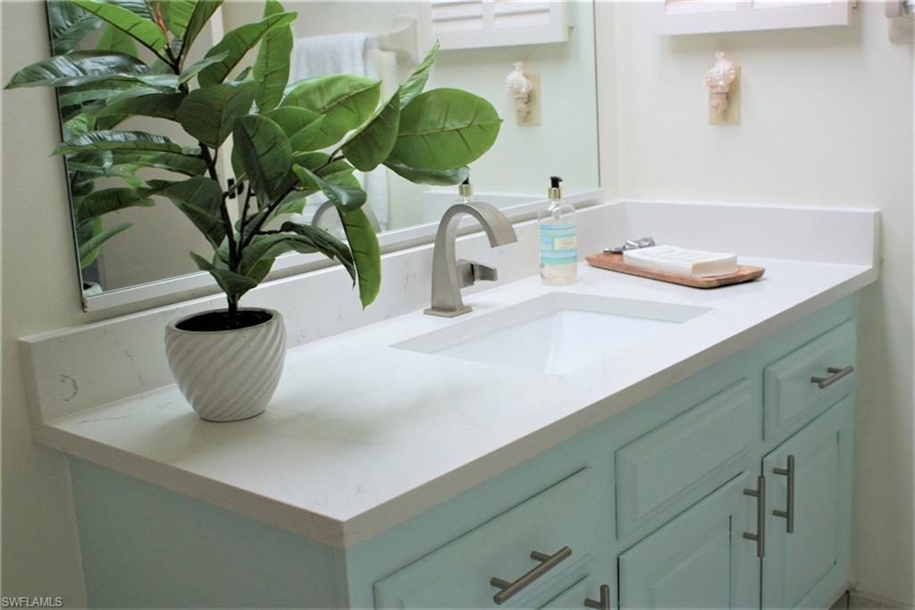 17 Bluebill Avenue, Unit 101 Naples, FL 34108 - Photo 19 of 23 a vase of flowers sitting on a sink