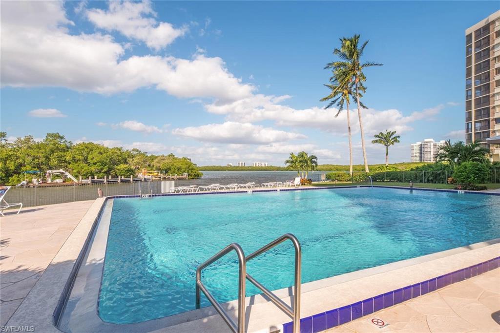 17 Bluebill Avenue, Unit 101 Naples, FL 34108 - Photo 5 of 23 a view of a lake with a palm tree