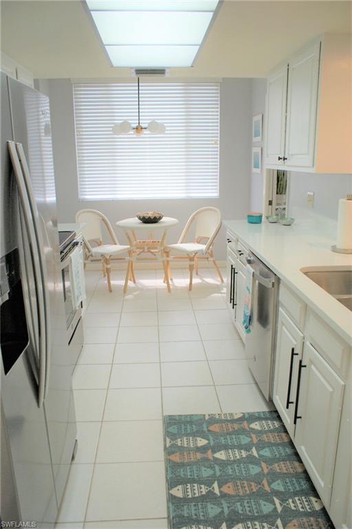 17 Bluebill Avenue, Unit 101 Naples, FL 34108 - Photo 9 of 23 a kitchen with stainless steel appliances a sink a stove a refrigerator and cabinets