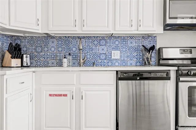 a kitchen with stainless steel appliances white cabinets and a sink