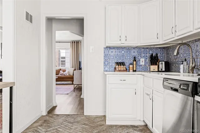 a kitchen with stainless steel appliances granite countertop a refrigerator and white cabinets