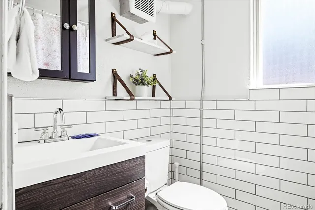 a bathroom with a sink mirror and toilet