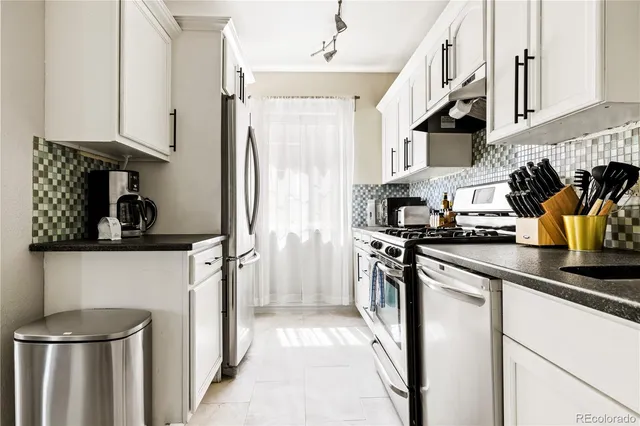 a kitchen with stainless steel appliances granite countertop a refrigerator a stove a sink and dishwasher