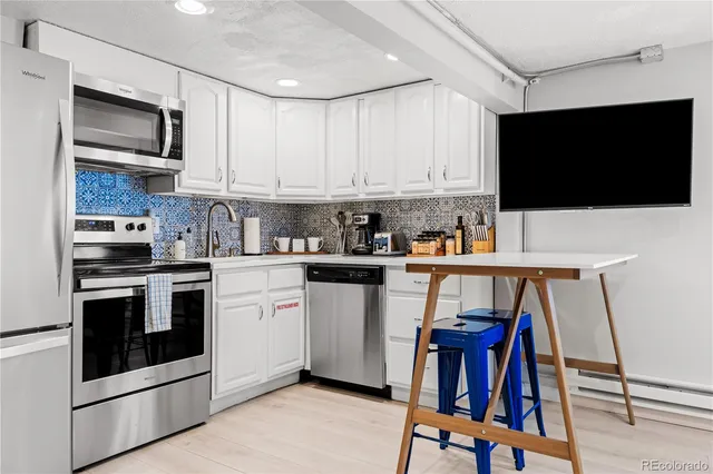 a kitchen with stainless steel appliances kitchen island granite countertop a stove top oven a sink and cabinets