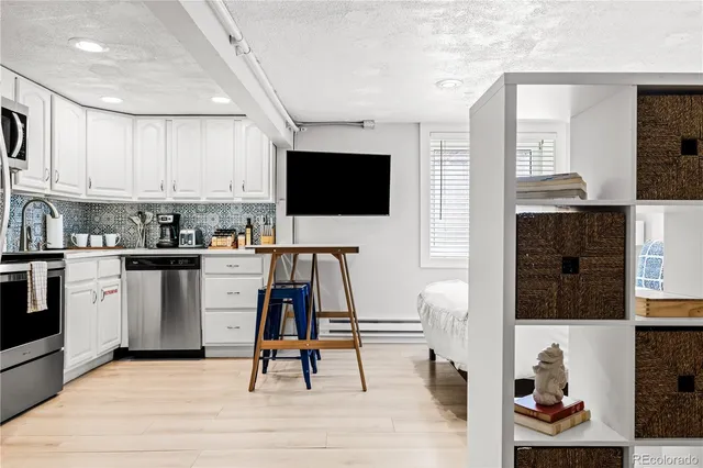 a kitchen with a sink appliances cabinets and furniture