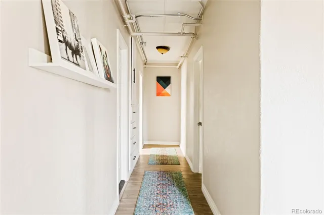 a view of a hallway with wooden floor