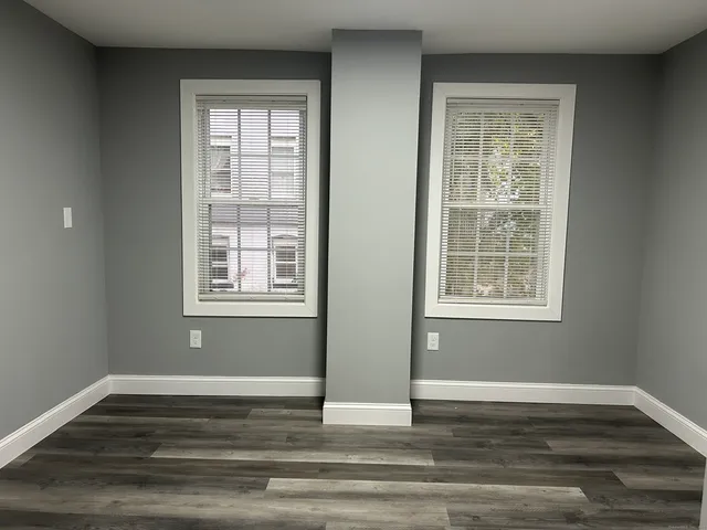 a view of a room with wooden floor and windows