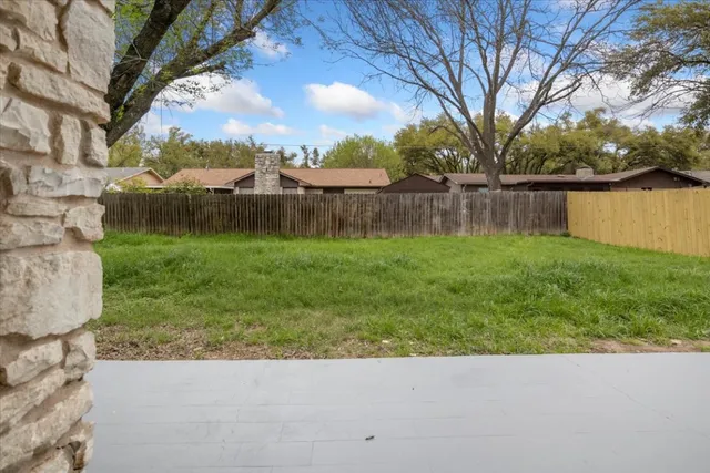a backyard of a house with lots of green space and fountain