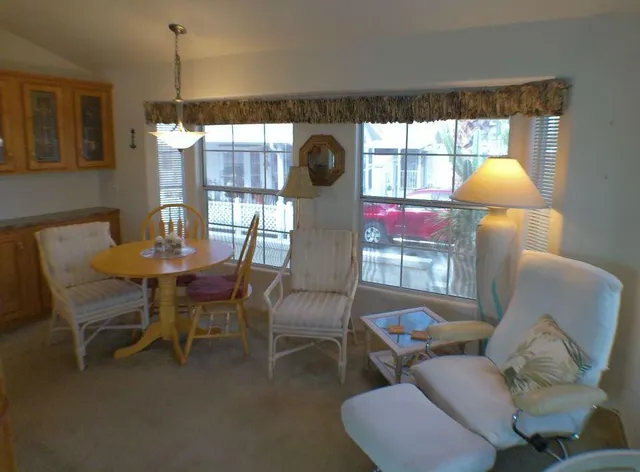 a living room with fireplace furniture and a large window