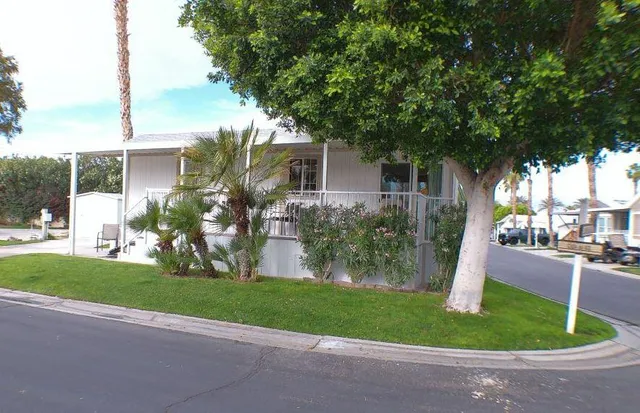 a front view of a house with a yard and trees