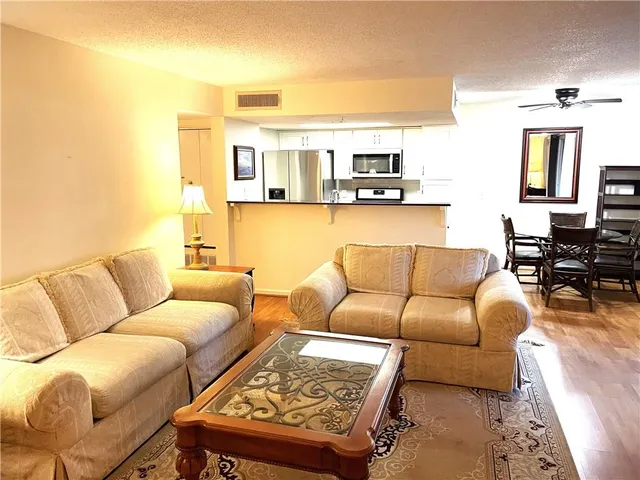 a living room with furniture and view of kitchen