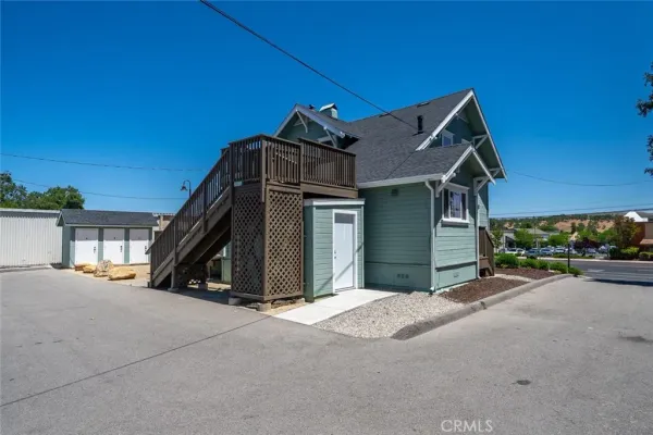 a view of a house with a floor to ceiling window and wooden fence