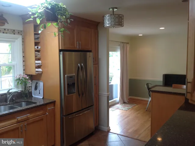 a kitchen with stainless steel appliances granite countertop a refrigerator and a sink
