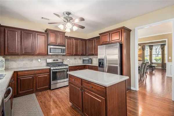 a kitchen with stainless steel appliances granite countertop a refrigerator a stove top oven a sink and dishwasher