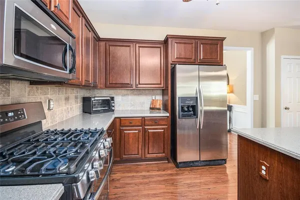 a kitchen with stainless steel appliances granite countertop a stove a refrigerator and a sink