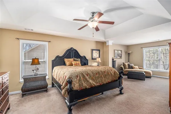 a spacious bedroom with a bed and a chandelier