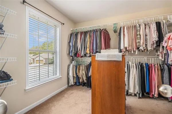 a view of walk in closet with clothes and shoes