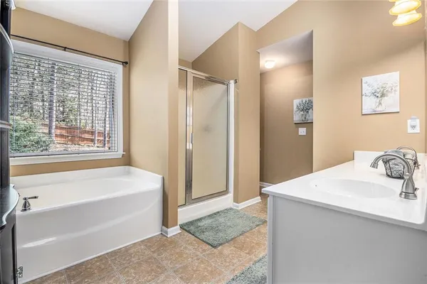 a bathroom with a tub sink and mirror