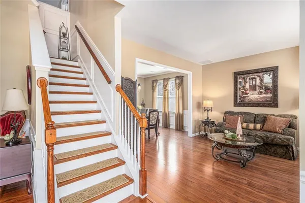 a living room with furniture and a dining table with wooden floor