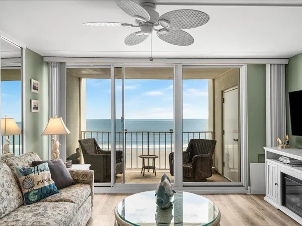 a living room with furniture and a floor to ceiling window