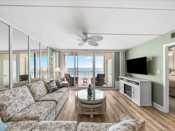 a living room with furniture a flat screen tv and a large window