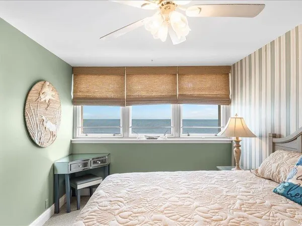 a bedroom with a bed a window and a chandelier