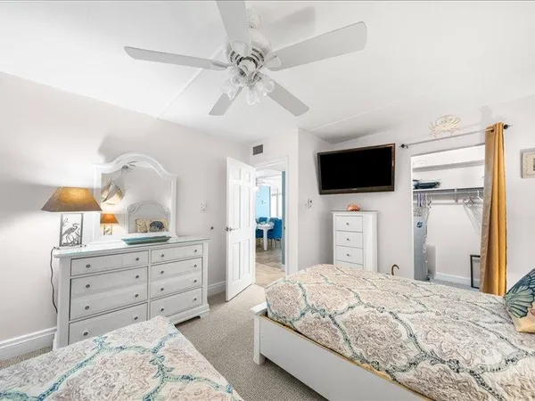 a bedroom with a large bed and a flat tv screen on dresser