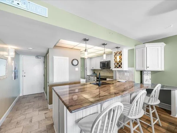 a kitchen with kitchen island granite countertop a table and chairs in it