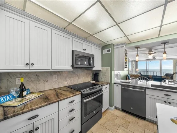a kitchen with stainless steel appliances granite countertop a sink stove and cabinets