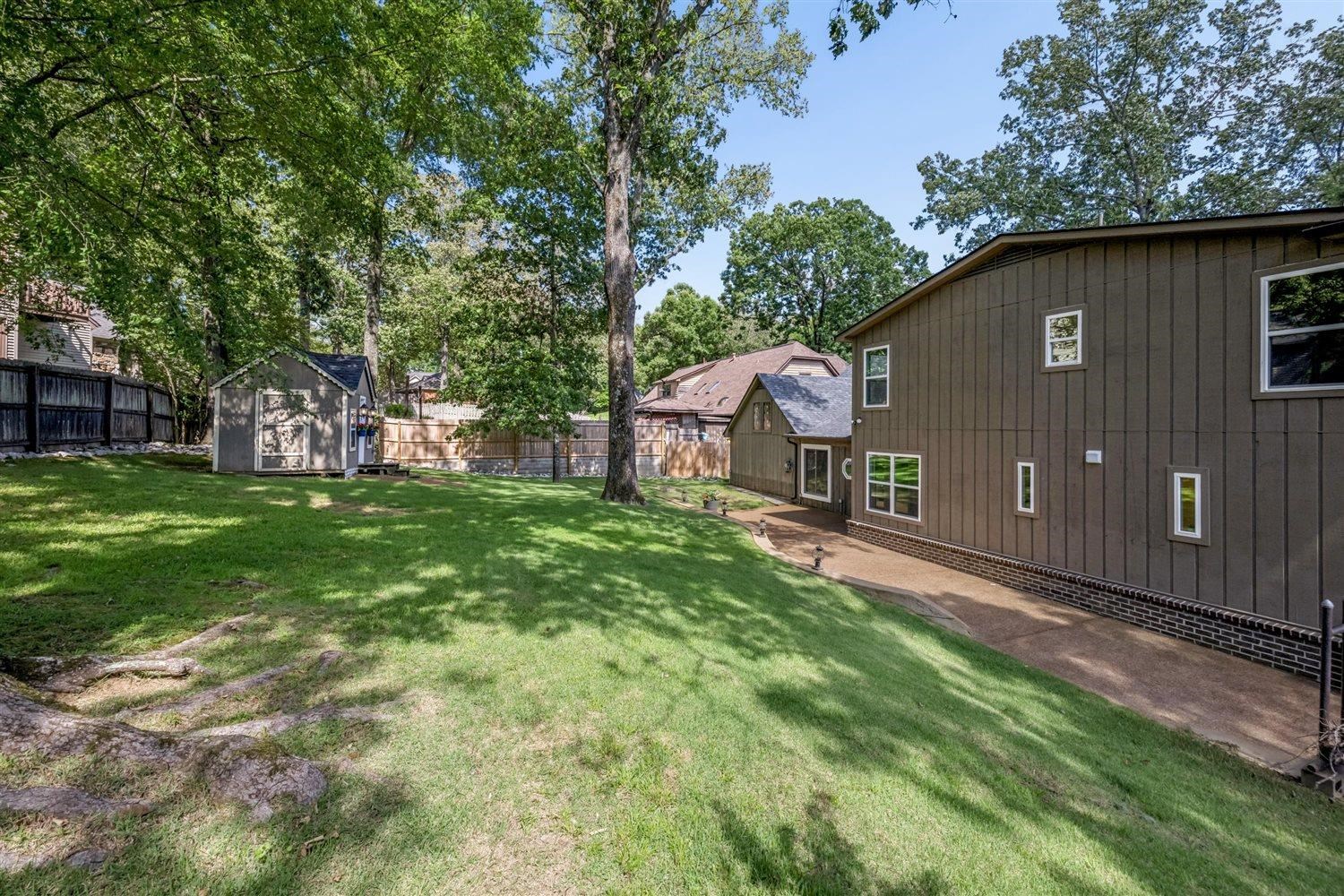 8970 Farmoor Road Germantown, TN 38139 - Photo 34 of 35 Expansive backyard featuring a green lawn, mature trees, and a detached storage shed