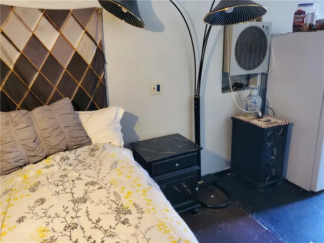 a bedroom with a bed and a lamp on dresser