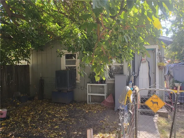 a backyard of a house with barbeque oven table and chairs