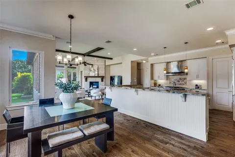 a kitchen with a dining table chairs stainless steel appliances and cabinets