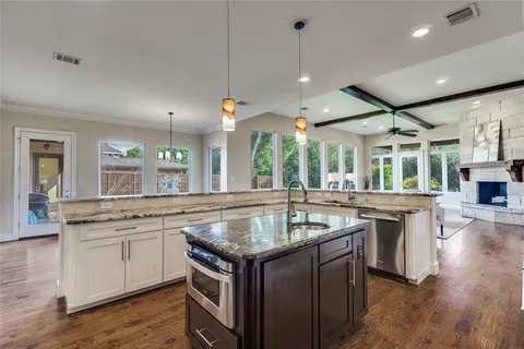a kitchen with a center island wooden floor and a view of living room