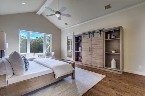 a bedroom with a large bed a chandelier and windows