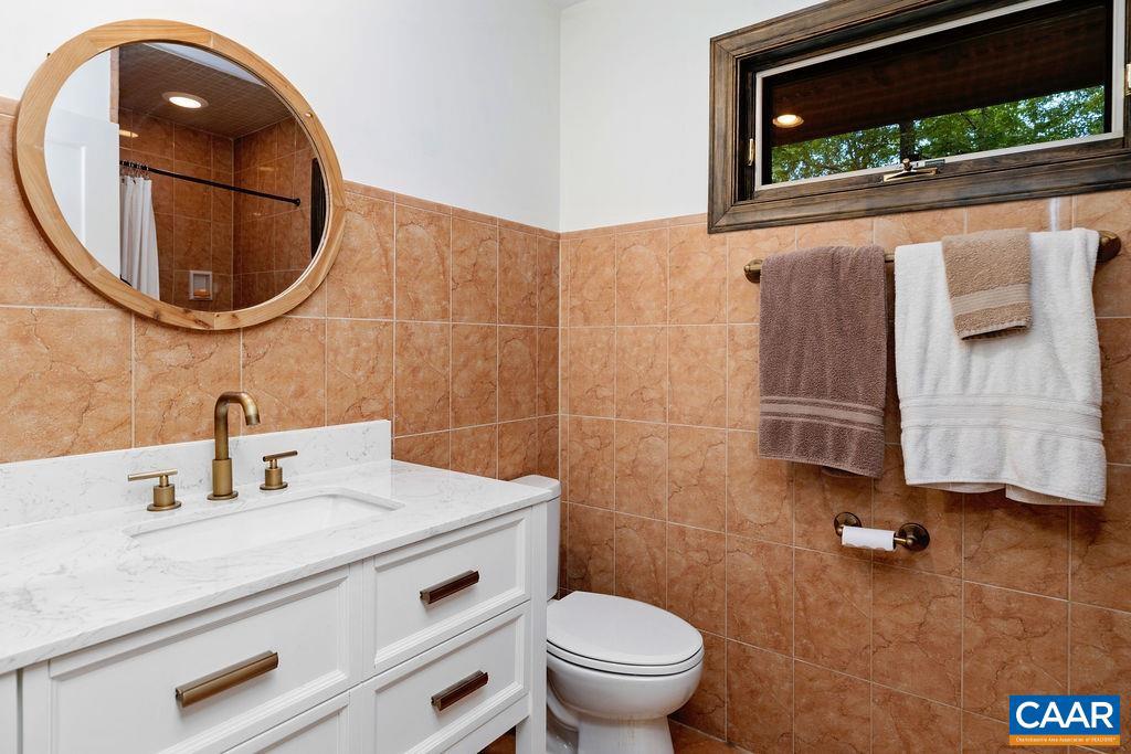 18 Grassy Overlook Wintergreen, VA 22967 - Photo 24 of 65 a bathroom with a sink a mirror a toilet and a window