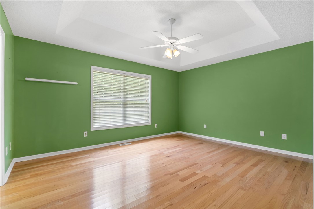 524 Pecan Grove Road Seneca, SC 29672 - Photo 13 of 30 Hardwood floors and a tray ceiling define this well-lit primary bedroom.