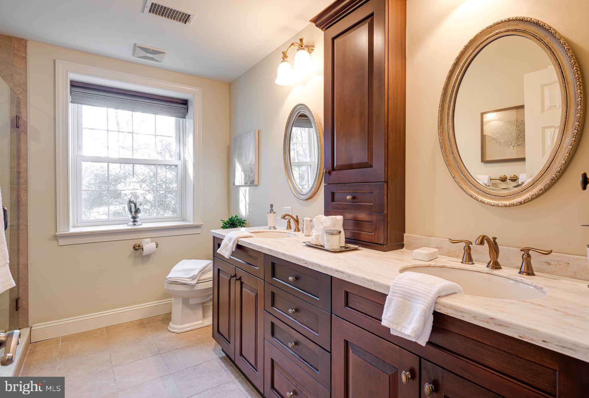 1040 Great Springs Road Bryn Mawr, PA 19010 - Photo 21 of 50 a bathroom with a granite countertop toilet a sink and a large mirror