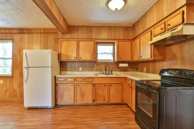 a kitchen with stainless steel appliances granite countertop a refrigerator a stove a sink and a microwave