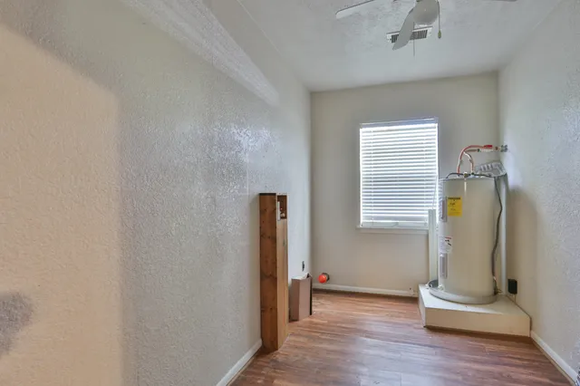 an empty room with wooden floor and a window