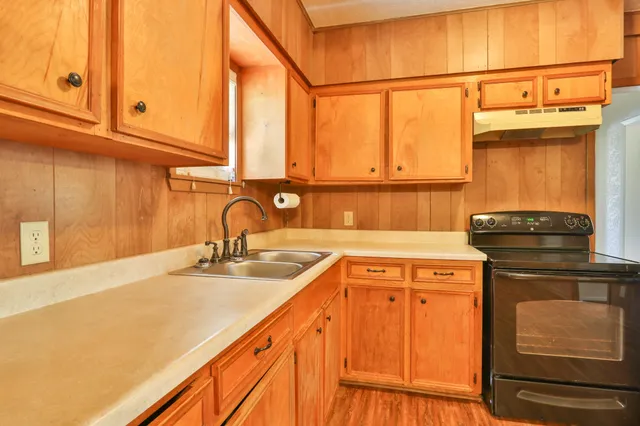 a kitchen with a sink cabinets and a window