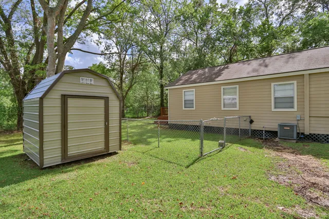 a backyard of a house with barbeque oven and a table and chairs