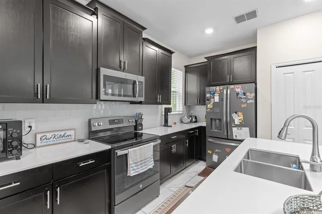 a kitchen with stainless steel appliances granite countertop a sink stove and refrigerator